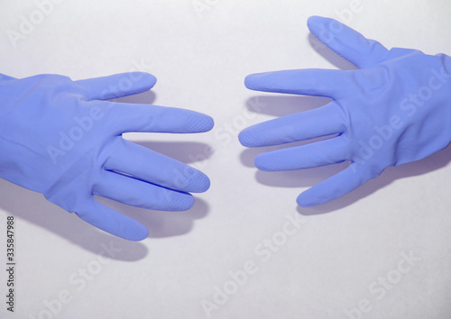 Blue gloves dressed on both hands on a white background stretch to each other © Наталья Анюхина