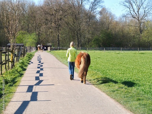 Woman leading a horse in Grevenbroich Wevelinghoven in Germany with Erft river