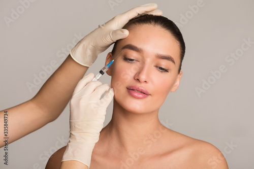 Woman with perfect skin receiving botox injection photo