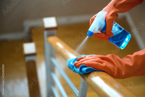 Hand use a wet spray and cloth to clean the wooden railings, disinfectants, cleanliness and health care photo