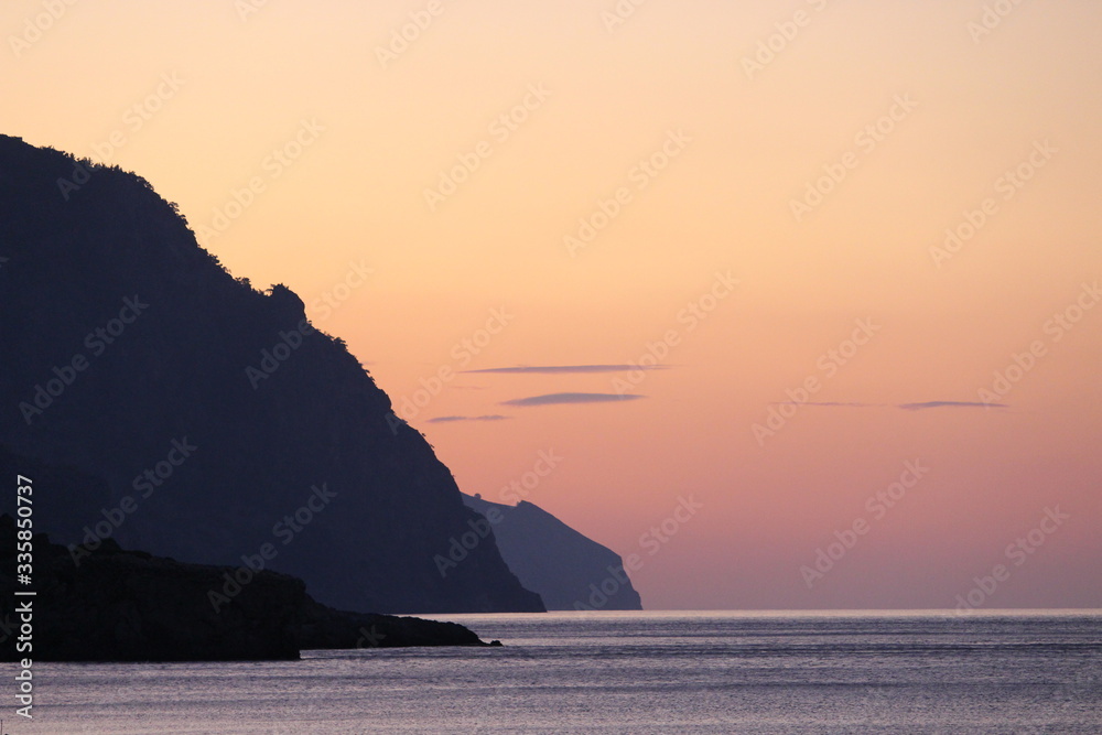 coucher de soleil avec des falaises tombant dans la mer
