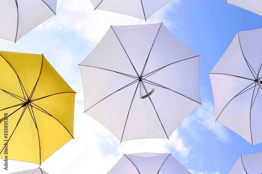 yellow and white umbrellas open against the blue sky