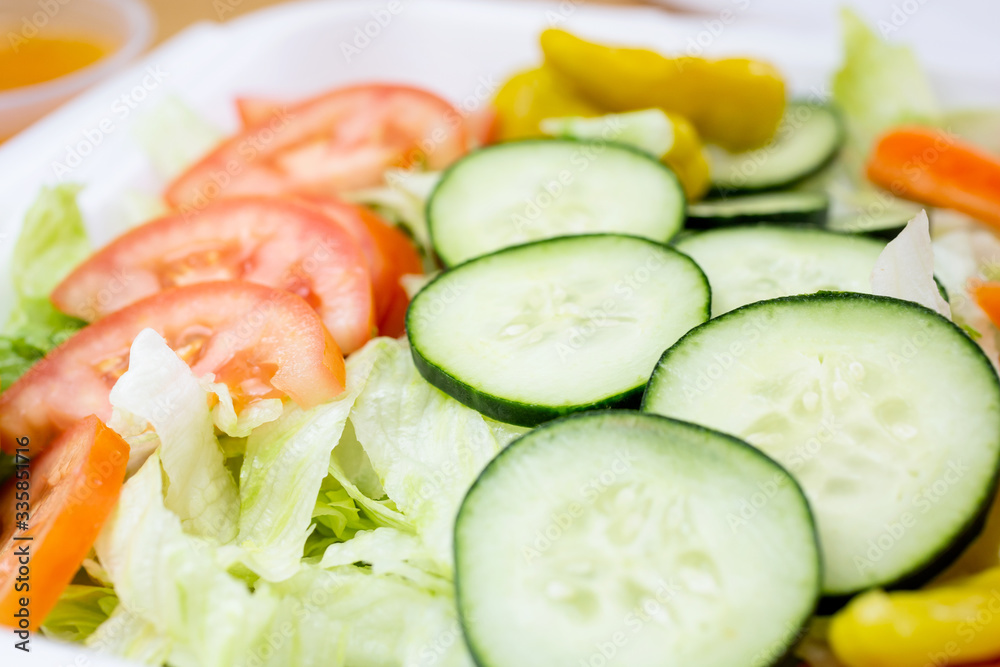 A closeup view of a common iceberg lettuce salad, in a restaurant or kitchen setting. A closeup view of a common iceberg lettuce salad, in a restaurant or kitchen setting.