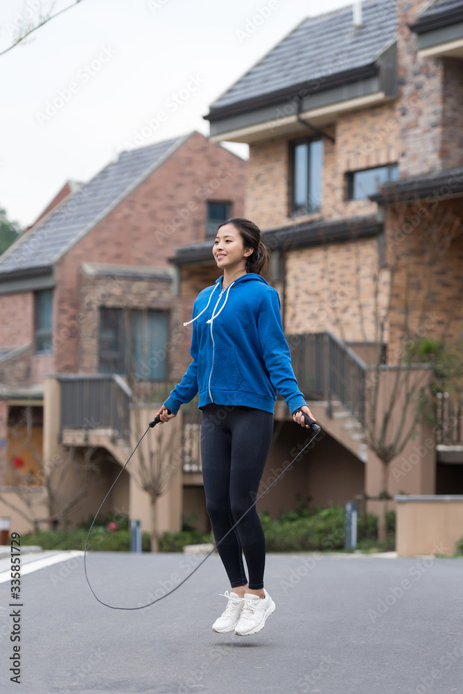 A young Asian woman skipping rope in the city