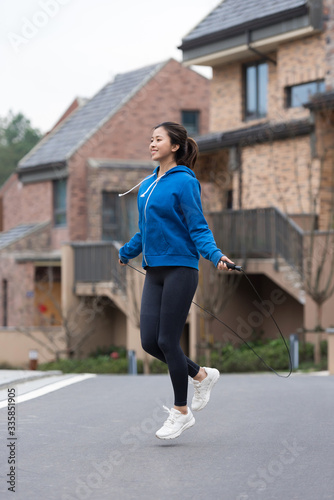 A young Asian woman skipping rope in the city