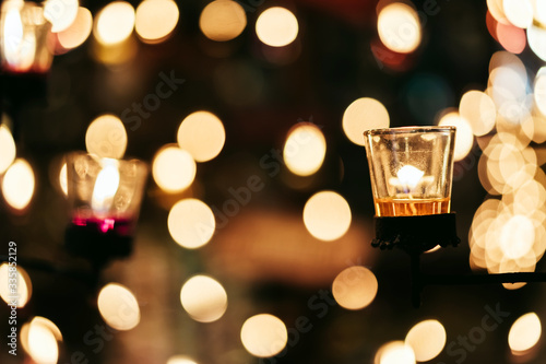 A Burning Candle in Clear Glass stick with steel rod Decorated in Hotel, Restaurant or Home. Selective Focus, Blurred Background with Bokeh.