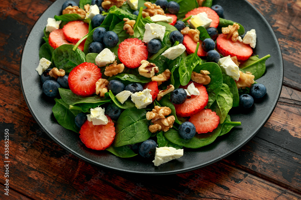 Spinach, Strawberry, blueberry salad with walnut and feta cheese. Summer healthy food