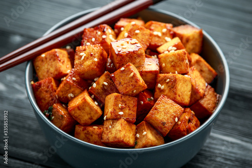 Fried Tofu in a bowl with chopstick and sesame seeds