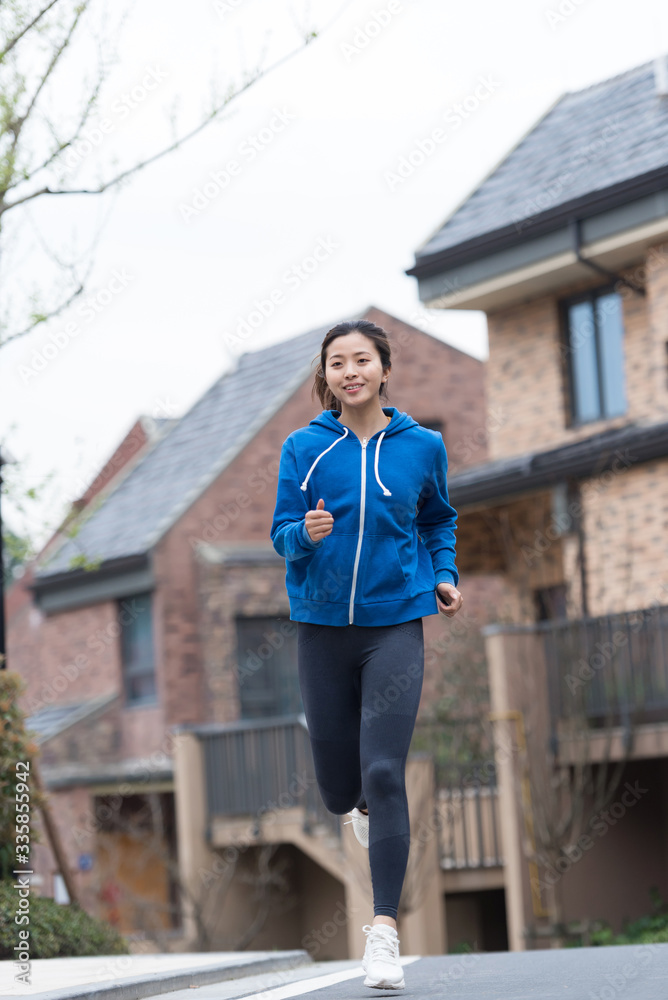 A young Asian woman jogging in the community A young Asian woman jogging in the community