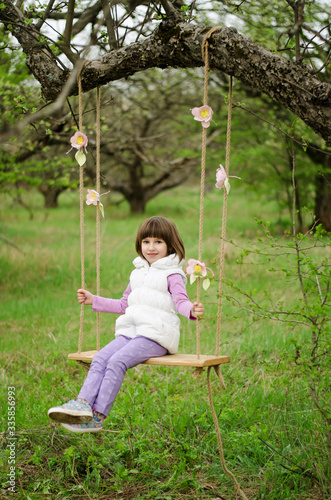 little girl sitting on a swing © alikusya
