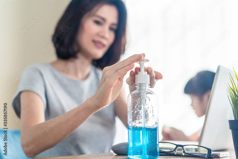 Asian young woman work from home to avoid close contact with people who are unwell. Girl always use hand sanitizer gel for clean hands often to prevent coronavirus infection. Covid-19 Social distance. Asian young woman work from home to avoid close contact with people who are unwell. Girl always use hand sanitizer gel for clean hands often to prevent coronavirus infection. Covid-19 Social distance.