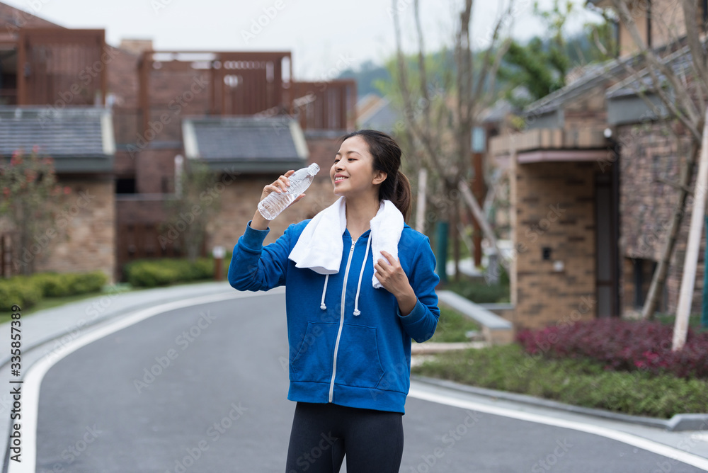 A young Asian woman is resting and drinking water