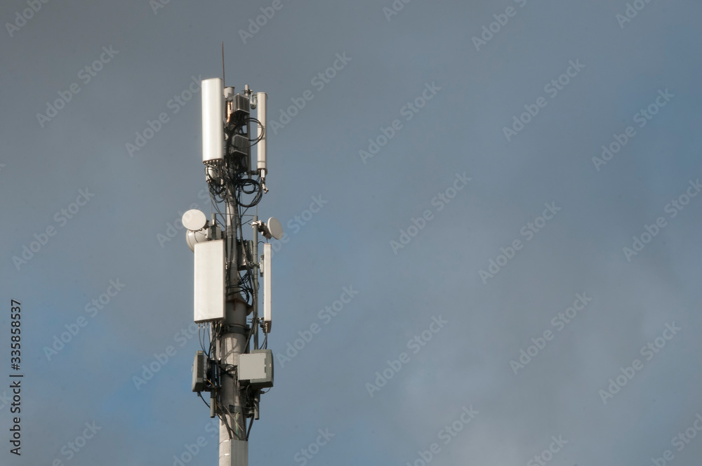 Cell tower closeup against a white sky.