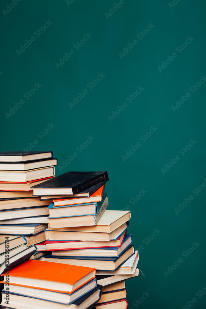 many stacks of educational books for learning preparation for college exams on a green background many stacks of educational books for learning preparation for college exams on a green background