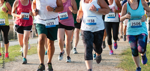 Front view of many runners racing around a lake photo