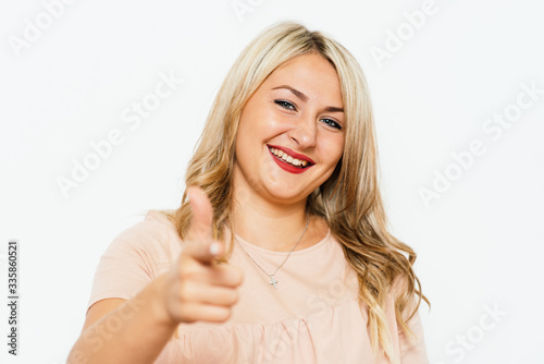 studio portrait of a beautiful girl pointing to the camera