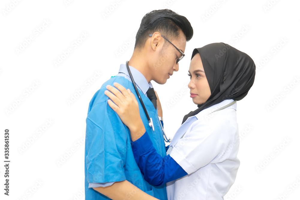 Portrait of couple Asian muslim female and male doctor wearing white coat and scrub uniform posing romantic in love on white background. Portrait of couple Asian muslim female and male doctor wearing white coat and scrub uniform posing romantic in love on white background.