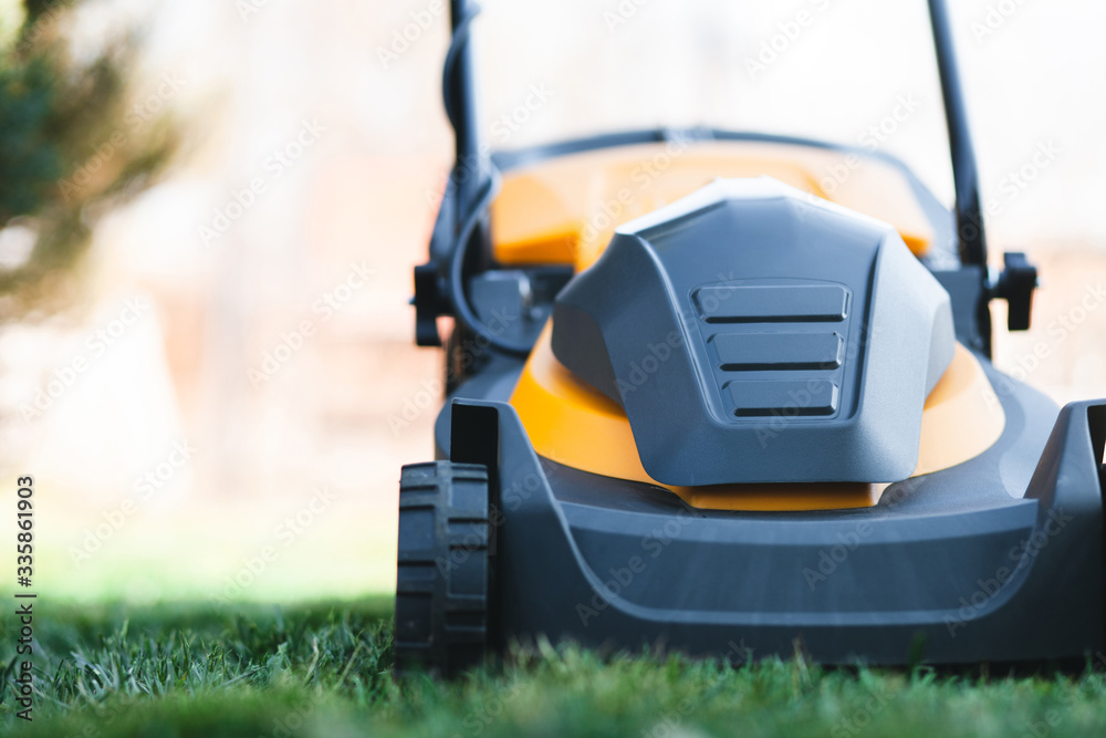 Electric lawn mower on grass front view Electric lawn mower on grass front view
