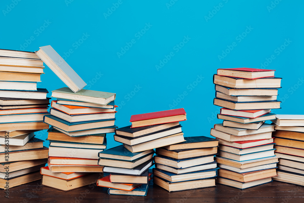 many stacks of educational books for learning preparation for college exams on a blue background many stacks of educational books for learning preparation for college exams on a blue background