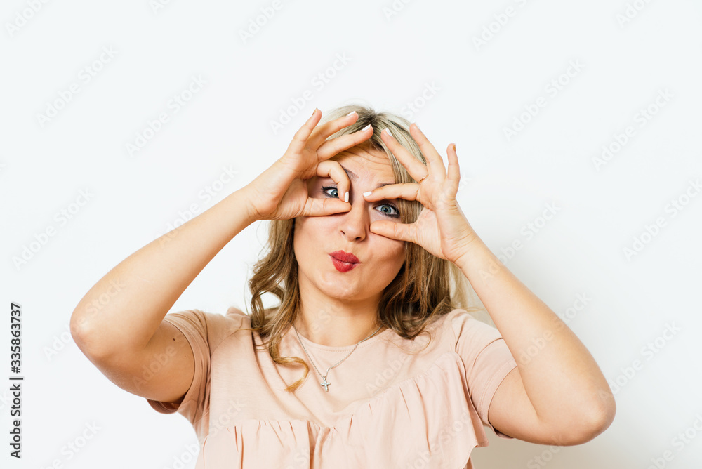 Woman looking through hands, making binoculars Woman looking through hands, making binoculars