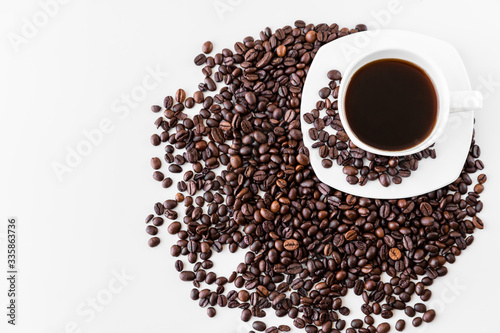 White cup with coffee and saucer, with scattered coffee beans on a white background. Great idea for a cafe, restaurant or cafeteria menu or as a sign.