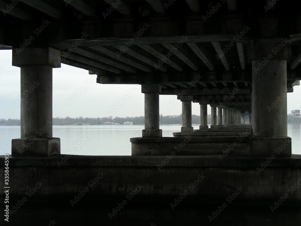 Bottom view of the reinforced concrete bridge over the river. Bridge piers.