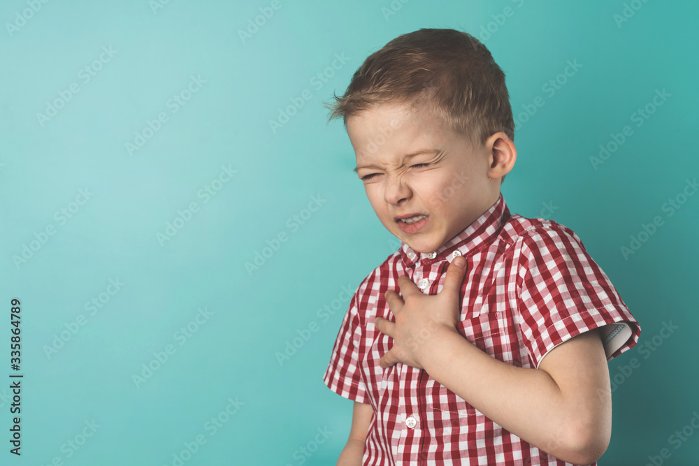 child is holding his chest with his hand. chest pain in a child Stock