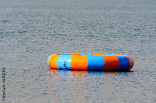 A blue and orange large inflatable ring in the sea at an outdoor activity centre photo