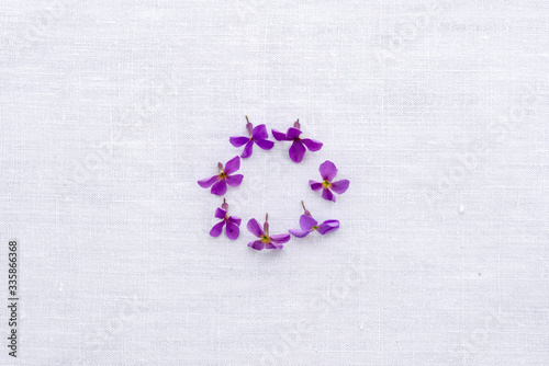 purple flower on white linen in a circle