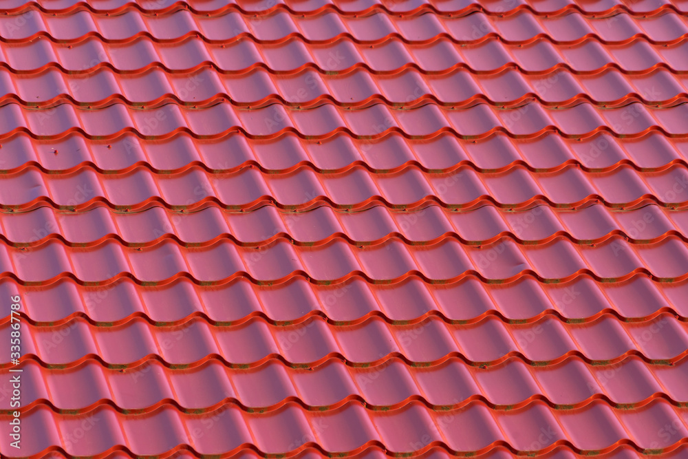 Roof of a house with modern red metal roof tiles Roof of a house with modern red metal roof tiles