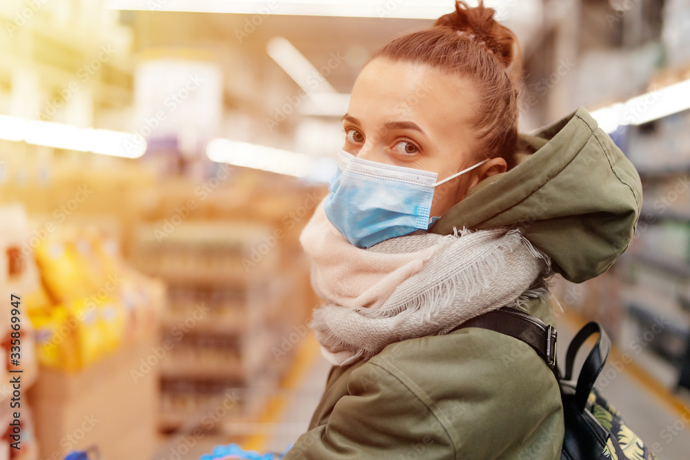 woman in medical gloves and mask in a supermarket with a trolley Stock ...