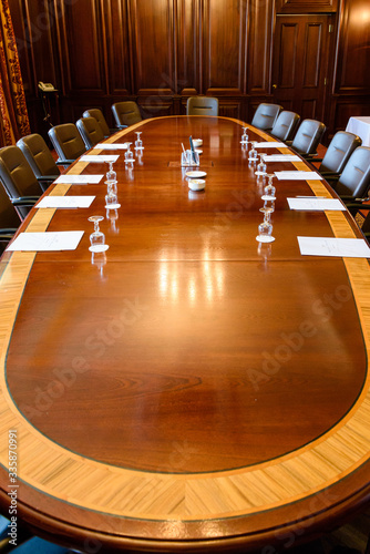 Obraz na plátně Large wooden table in a board room with wood panelling, set up for a meeting