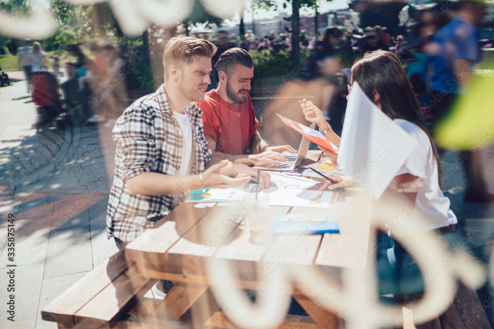 Group of people sitting in street cafe