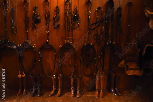 Bridles and riding boots in a stable photo