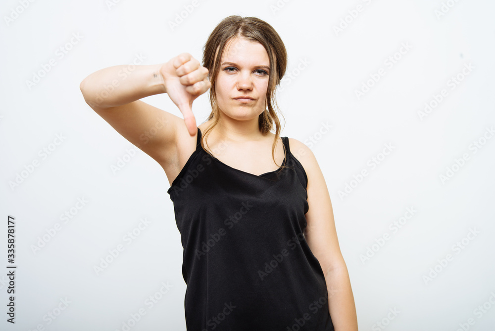 Woman showing a thumb down gesture Woman showing a thumb down gesture