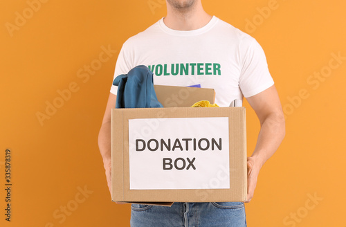 Volunteer with donations for orphans on color background © Pixel-Shot