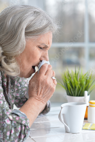 Close up portrait of sick senior woman sitting at table