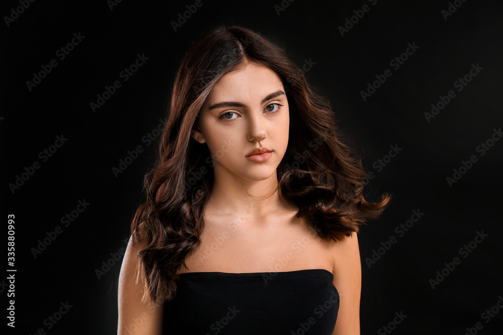 Young woman with beautiful curly hair on dark background Young woman with beautiful curly hair on dark background