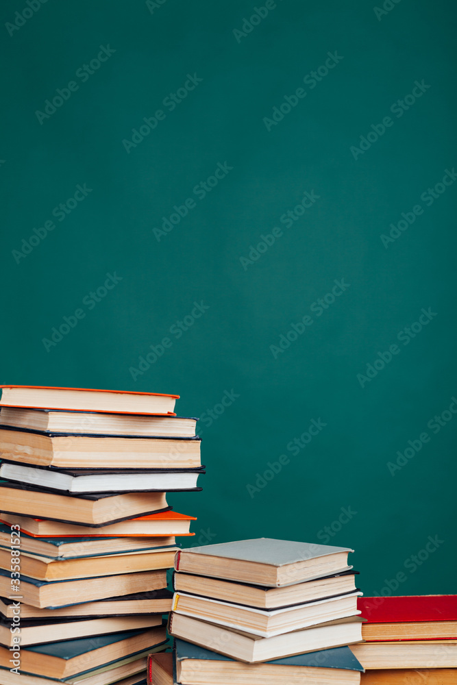 many stacks of educational books for learning preparation for college exams on a green background many stacks of educational books for learning preparation for college exams on a green background