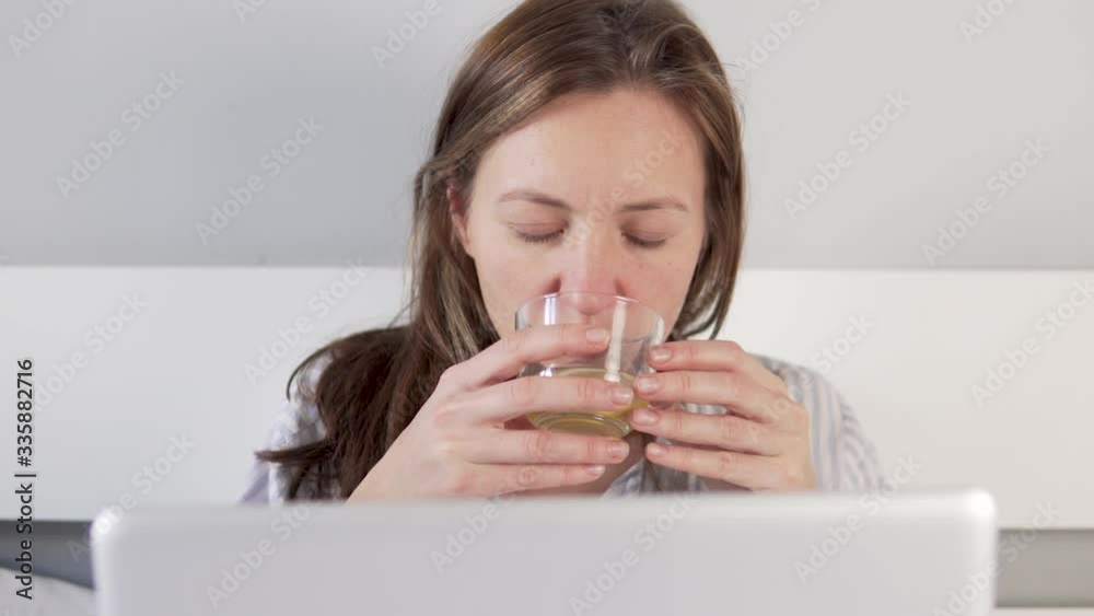 Concept Woman works on a computer from home. Sick woman lies in bed with laptop and corresponds Concept Woman works on a computer from home. Sick woman lies in bed with laptop and corresponds