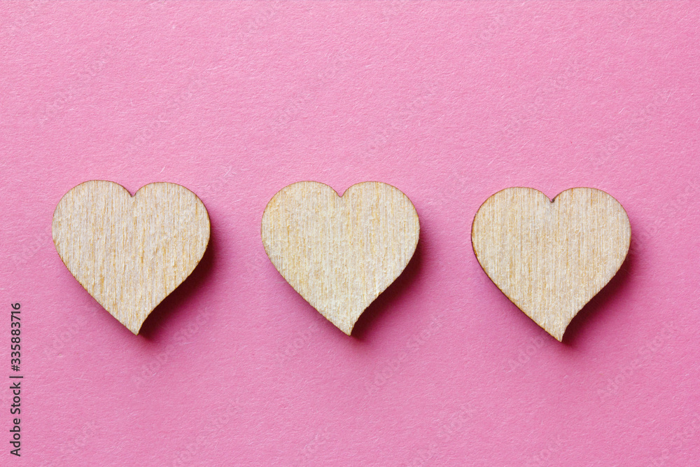three heart shaped wooden blocks for icons on a pink background. Customer service experience and satisfaction survey concept three heart shaped wooden blocks for icons on a pink background. Customer service experience and satisfaction survey concept