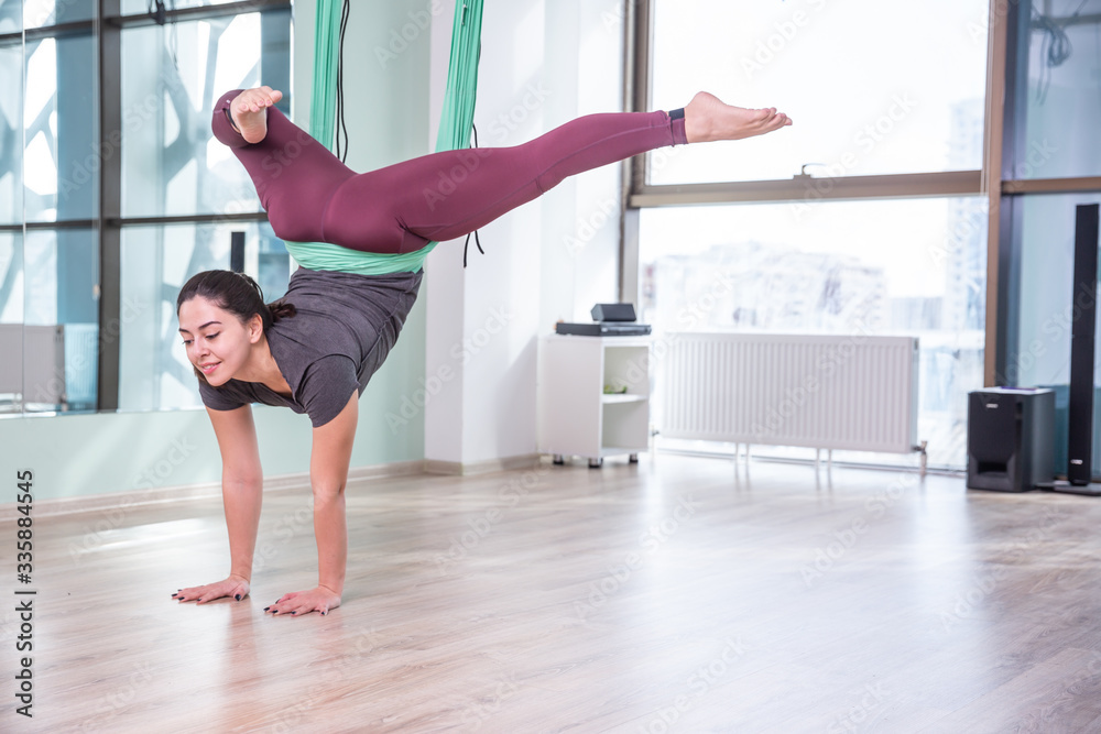 Photo of young woman practicing yoga indoor. Beautiful girl practice yoga in class. Yoga studio instructor. Blurred background.