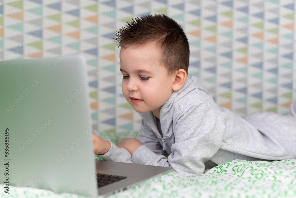 Stay at home quarantine coronavirus pandemic prevention. A child learns online on a laptop during quarantine. Distance learning. Prevention epidemic. COVID-19. Stay at home quarantine coronavirus pandemic prevention. A child learns online on a laptop during quarantine. Distance learning. Prevention epidemic. COVID-19.