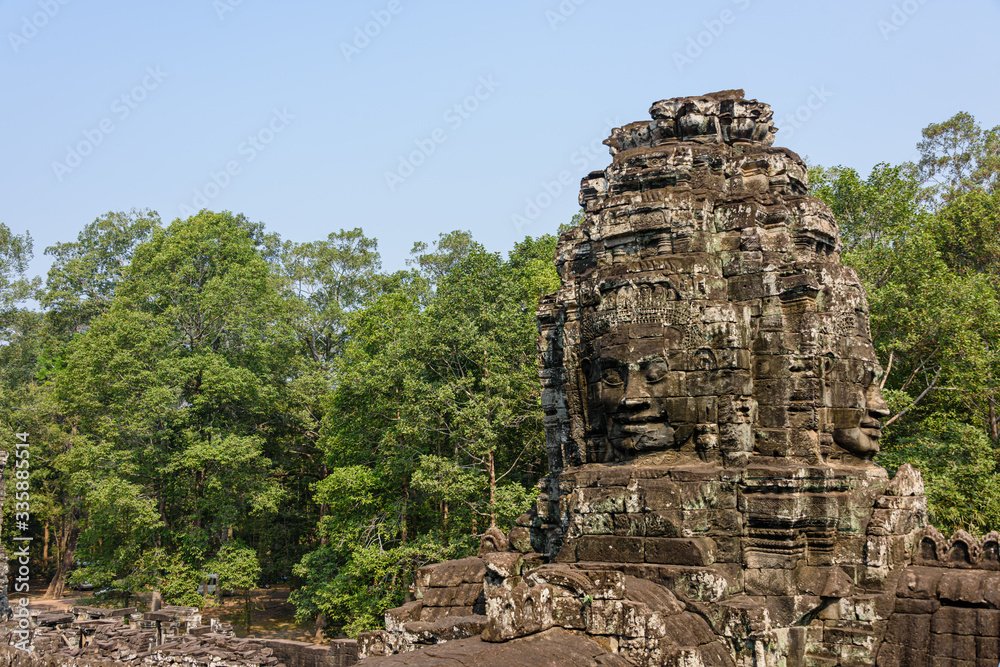 Multiple large faces of the Buddha are carved in to the side of the Unesco World Heritage site of Ankor Thom, Siem Reap, Cambodia