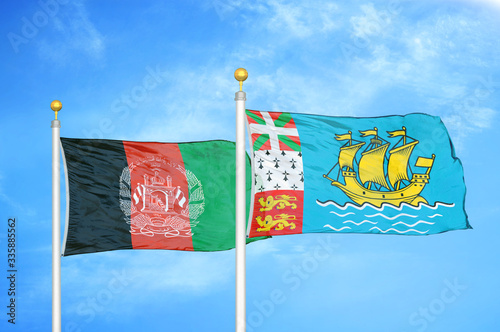 Afghanistan and Saint Pierre and Miquelon  two flags on flagpoles and blue cloudy sky photo