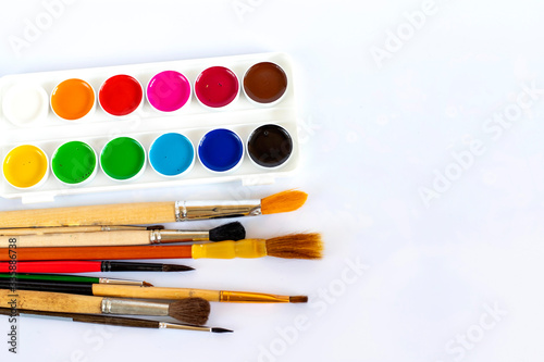 Paints and brushes on a white isolated background.