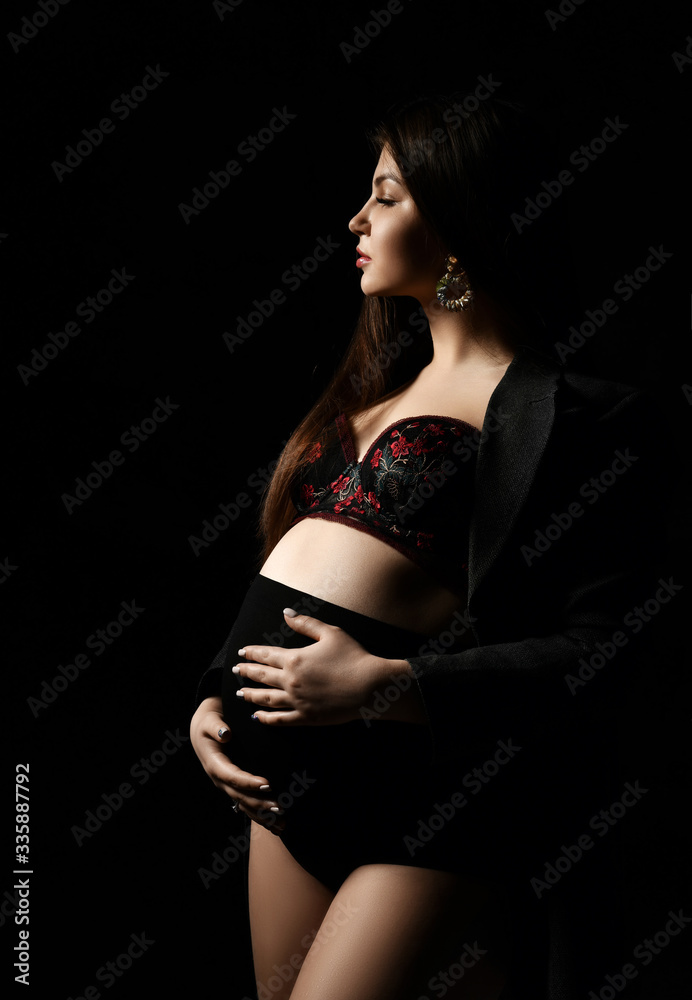 Young beautiful slim pregnant woman with long hair in posing on black background. Pregnancy motherhood, new born life expectation Young beautiful slim pregnant woman with long hair in posing on black background. Pregnancy motherhood, new born life expectation