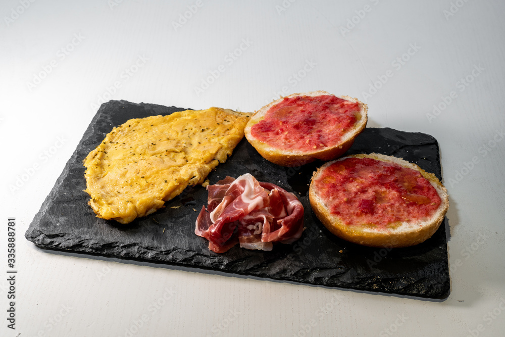 Fototapeta premium Omelette, bread with tomato and iberic ham