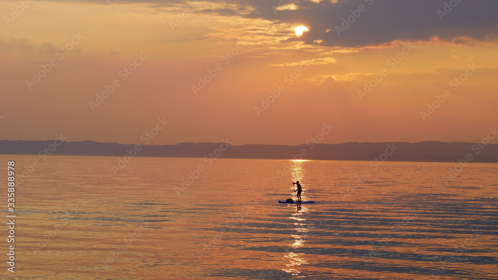 Sonnenuntergang, mit Mensch auf Surfbrett