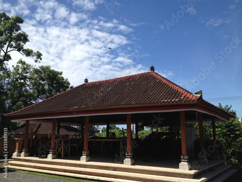Un complejo de templos abiertos con un gran techo de tejas en el pueblo. Día despejado y soleado. Indonesia, Bali